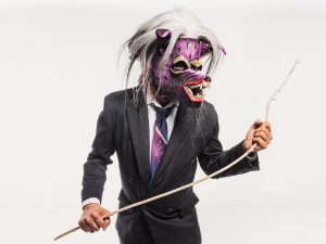 Studio Shot of a Man in a Suit and Purple Mask