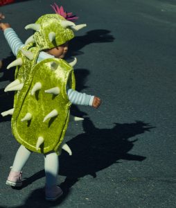 a child in a costume walking down a street